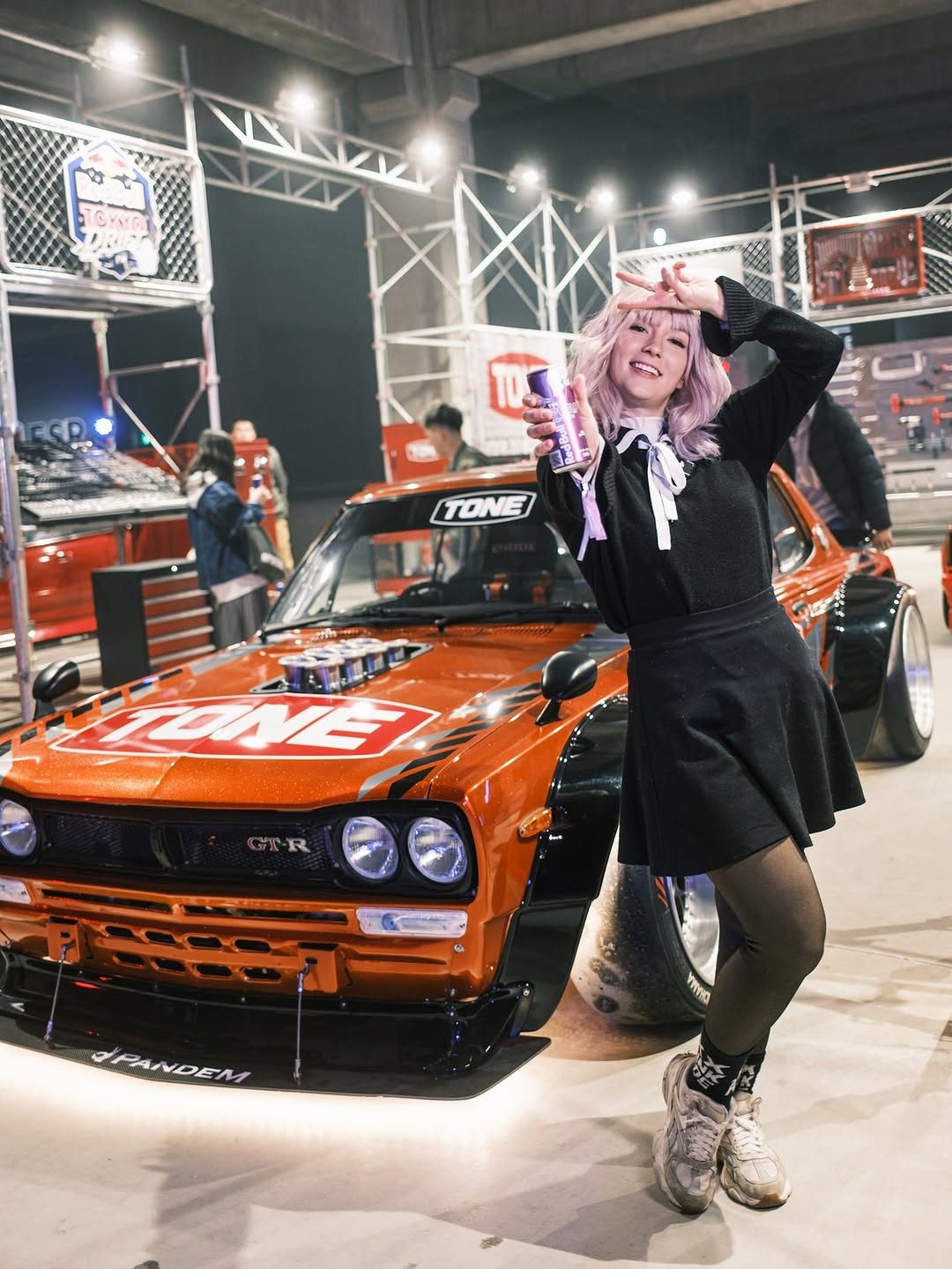 A model posing with a car at Red Bull Tokyo Drift