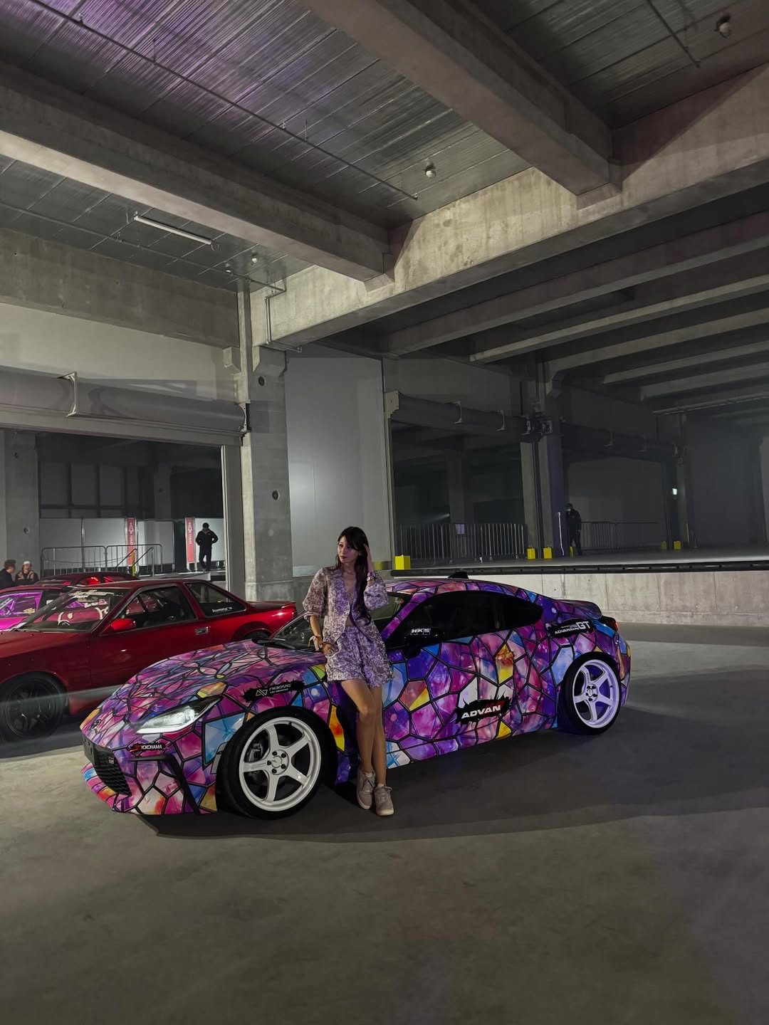 A model and a car under the event lights